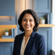 A professional portrait of a happy South Asian woman smiling, representing a satisfied customer for a trust badge.